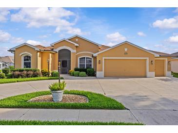 Beautiful one-story home with a well-manicured lawn and a spacious driveway at 5339 Pond Crossing Pl, Leesburg, FL 34748