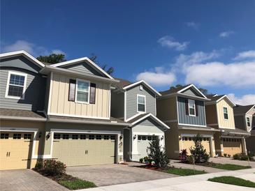 Charming townhomes featuring colorful siding, brick driveways, and attached garages in a well-maintained community at 1003 E 10 St, Apopka, FL 32703