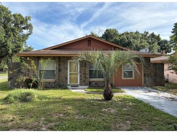 Charming single-story home featuring stone accents, a palm tree, and a well-maintained front yard at 3700 Washington St, Sanford, FL 32771