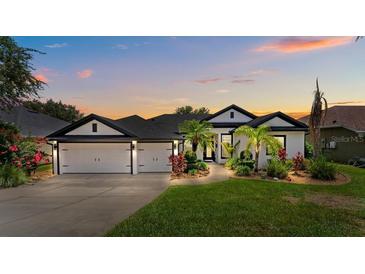 Charming home with a well-manicured lawn, lush landscaping, and a three-car garage at 533 Quail Down Dr, Debary, FL 32713