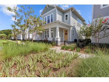 Charming two-story home with inviting front porch and beautifully landscaped yard and black metal fence at 923 Colie Aly, Winter Garden, FL 34787
