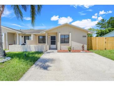 Charming single-story home with a well-manicured lawn and welcoming front entrance with beige concrete driveway at 1920 Dardanelle Dr, Orlando, FL 32808