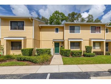 Charming townhouse with manicured landscaping, a green front door, and ample natural light at 2208 Mcmahon Ct # 1033, Orlando, FL 32812
