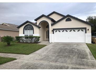 Charming single Gathering home featuring neutral paint, an arched doorway, and manicured landscaping at 2505 Osprey Creek Ct, Kissimmee, FL 34747