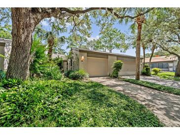Charming home featuring a two-car garage and lush landscaping surrounded by mature trees at 616 Woodridge Dr, Casselberry, FL 32730