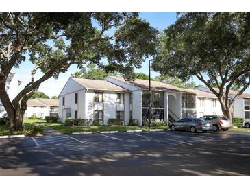 Two-story condo building with ample parking and mature shade trees surrounding the property at 954 Courtyard Ln # 52, Orlando, FL 32825