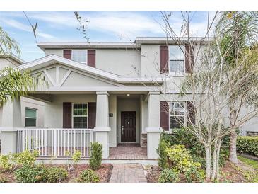 Charming two-story home with a well-manicured lawn and inviting front porch featuring brown shutters at 11139 Cyrilla Woods Dr, Orlando, FL 32832