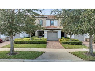 Charming townhome featuring a well-manicured front yard and a lovely tile roof at 14088 Tarvin St, Orlando, FL 32832