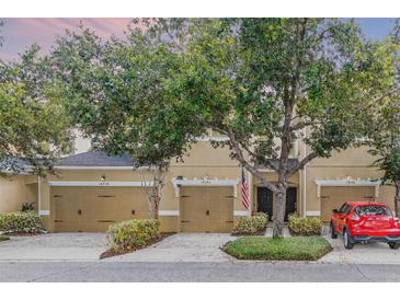 Inviting townhome exterior showcasing a well-manicured lawn and a charming two-car garage at 14242 Desert Haven St # Ge, Windermere, FL 34786