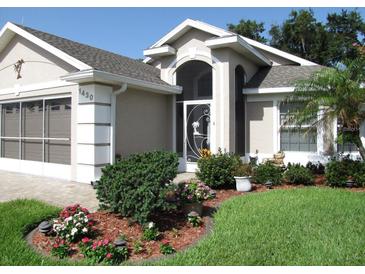 Charming home featuring a well-manicured lawn and beautiful landscaping in the front yard at 1430 Challenger Ave, Davenport, FL 33897