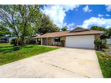 Charming single-story brick home with a well-maintained front yard and attached two-car garage at 2005 Dalton Ave, Deltona, FL 32725