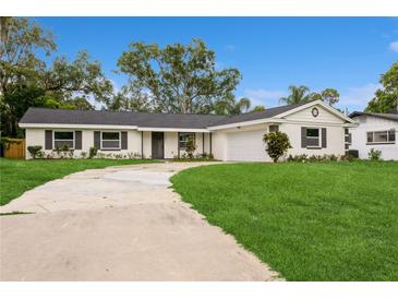 Charming single-story home featuring a spacious front yard, and a long curved driveway at 5021 Saint Marie Ave, Belle Isle, FL 32812