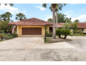 Charming single Gathering home with a red tile roof and beautifully landscaped front yard at 5057 Maui Cir # 15, Orlando, FL 32808
