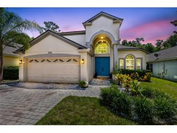 Stunning two-story home with a blue front door, lush landscaping, and a two-car garage at 1617 Song Sparrow Ct, Sanford, FL 32773