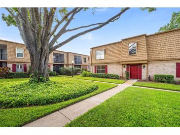 Attractive two-story condo building with lush lawn, mature trees and red front doors and shutters at 200 St Andrews Blvd # 601, Winter Park, FL 32792