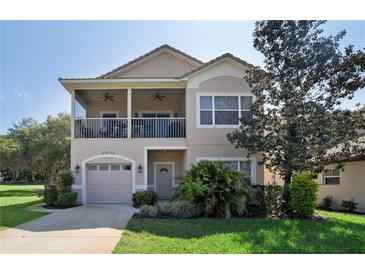Two-story home showcasing a balcony, manicured lawn, and attached one-car garage at 20130 Sunset Landing Ave, Groveland, FL 34736