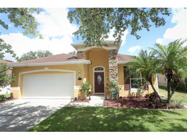 Charming one-story home featuring a stucco exterior, a stone column, and a well-manicured front lawn at 203 Brookgreen Way, Deland, FL 32724