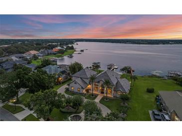 Stunning lakefront home with lush landscaping, private dock, and panoramic sunset views at 2937 Butler Bay N Dr, Windermere, FL 34786