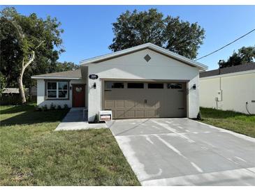 Newly renovated single-Gathering home with a freshly painted exterior, a new driveway, and well-maintained landscaping at 320 W Necho Ave, Lake Alfred, FL 33850