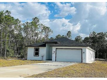 Charming single Gathering home showcasing a well-manicured lawn and an attached two-car garage at 3431 Orchid Dr, Indian Lake Estates, FL 33855
