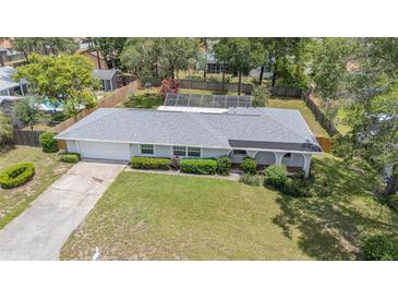 Charming home featuring a spacious front yard, mature landscaping, and a screened-in pool area at 419 W Orange St, Altamonte Springs, FL 32714