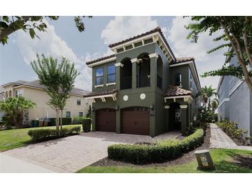 Beautiful two-story home with a red brick driveway, two-car garage, and well-maintained landscaping at 1156 Castle Pines Ct, Reunion, FL 34747