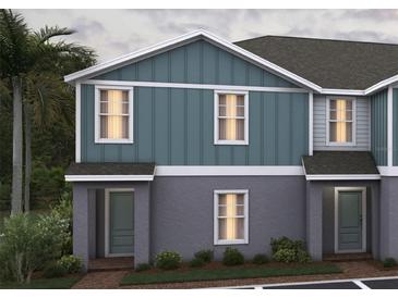 Charming two-story townhome featuring a blend of gray and blue siding, offering a modern and appealing exterior design at 2420 Cabinwood Range Way, Eustis, FL 32726