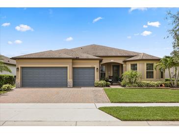 Charming one-story home featuring a three-car garage, brick driveway and meticulously landscaped front yard at 2896 Matera Dr, St Cloud, FL 34771