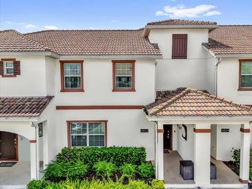 Charming two-story townhome featuring a red tile roof and well-maintained front landscaping at 4802 Lullaby Ln, Kissimmee, FL 34746
