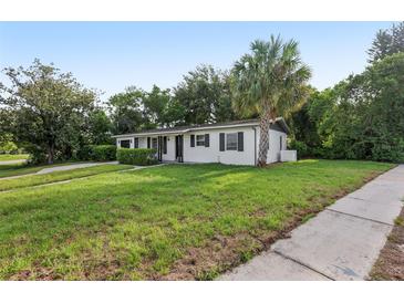 Charming home featuring a well-manicured lawn and a mature palm tree in a serene neighborhood setting at 1320 E Lombardy Dr, Deltona, FL 32725