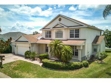 Charming two-story home featuring a well-maintained lawn, lush landscaping, and a brick-paved driveway at 2512 Chapala Dr, Kissimmee, FL 34746