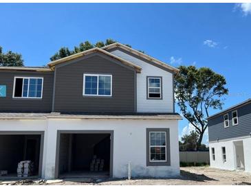 New construction townhome showcasing a two-tone paint scheme, garage and new windows at 4240 Campsite Loop, Orlando, FL 32824