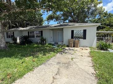 Charming single-story home featuring a concrete driveway and mature trees at 1047 Clay Blvd, Eustis, FL 32726