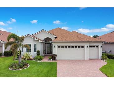 Charming single-story home with well-manicured lawn, mature landscaping, and a three-car garage at 1104 Sawgrass Dr, Winter Haven, FL 33884