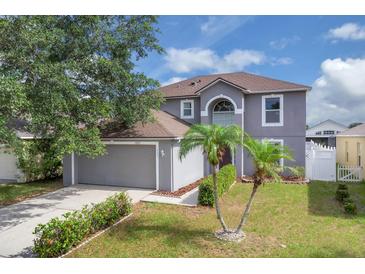 Two-story home with landscaped lawn and attached two-car garage at 16053 Wilkinson Dr, Clermont, FL 34714