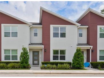Inviting exterior of townhome featuring red accents, manicured landscaping, and large windows at 193 E Warren Ave, Longwood, FL 32750
