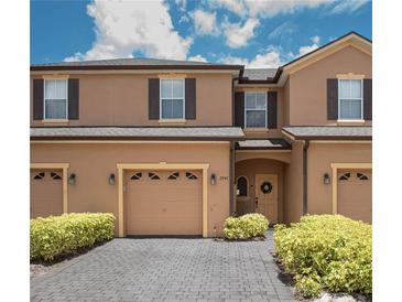 Charming townhome featuring a two-car garage, shuttered windows, and a welcoming entrance with tasteful landscaping at 2241 Retreat View Cir, Sanford, FL 32771