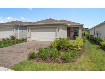 Charming single-story home featuring a well-manicured front yard, brick driveway, and a two-car garage at 2759 Purple Meadow Ct, Minneola, FL 34715