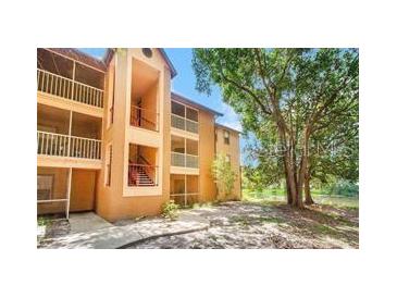 Condo exterior with balconies and stairs, set by a lake and trees at 958 Salt Pond Pl # 103, Altamonte Springs, FL 32714