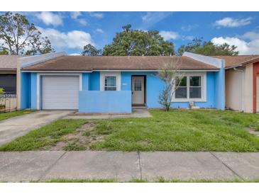 Charming single-Gathering home featuring a light blue exterior, attached garage, and a cozy front yard at 978 Calanda Ave, Orlando, FL 32807