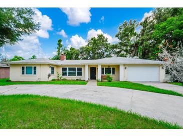 Charming single-story home featuring a well-manicured lawn and a two-car garage at 1420 Rock Lake Dr, Orlando, FL 32805