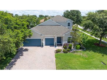Stunning two-story home featuring a three-car garage, well-manicured lawn, and beautiful landscaping at 3994 Knott Dr, Apopka, FL 32712