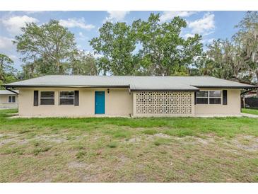 Charming home featuring a bright blue front door, geometric design and mature trees in the front yard at 4085 Cypress Bend, Geneva, FL 32732
