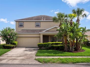 Charming two-story home with a well-maintained lawn and beautiful tropical landscaping at 512 Bella Rosa Cir, Sanford, FL 32771