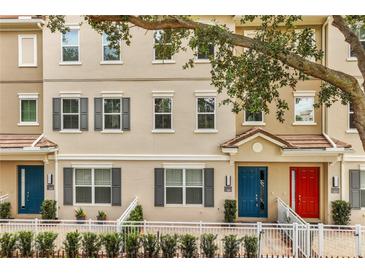 Charming townhouse exterior featuring neutral paint, grey shutters, and colorful front doors at 661 Hangnest Ln, Lake Mary, FL 32746