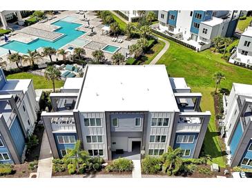 A modern condo building overlooks a luxurious pool area with lush landscaping and contemporary architecture at 7770 Sandy Ridge Dr # 117, Reunion, FL 34747