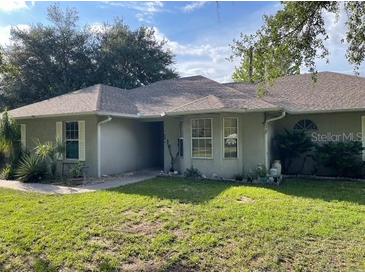 Cozy single-story home features well-manicured lawn, mature trees and simple landscaping at 824 Berryhill Cir, Fruitland Park, FL 34731