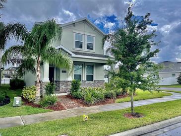 Charming two-story home with stone accents and inviting landscaping, including mature palms at 11070 Longleaf Woods Dr, Orlando, FL 32832