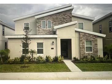 Modern two-story home with a stone facade and well-maintained landscaping at 1201 Challenge Dr, Davenport, FL 33896
