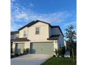 Charming two-story home featuring a well-maintained lawn and an attached two-car garage at 1635 Wynford Cir, Tavares, FL 32778